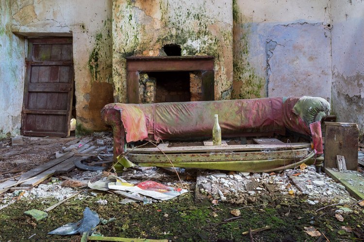 sofa and a bottle of wine in an old schoolhouse from An Essence of Presence exhibition
